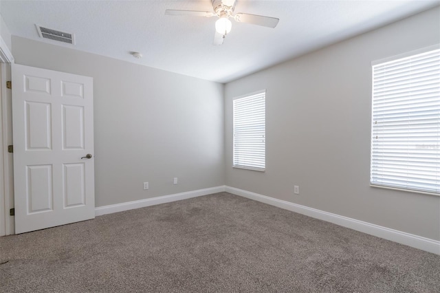 spare room featuring ceiling fan and carpet