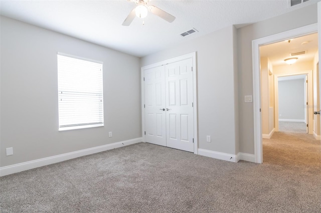 unfurnished bedroom with light carpet, a closet, and ceiling fan