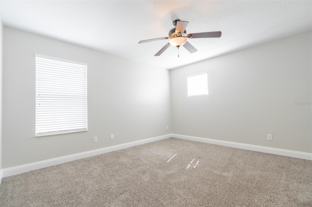 carpeted spare room featuring ceiling fan