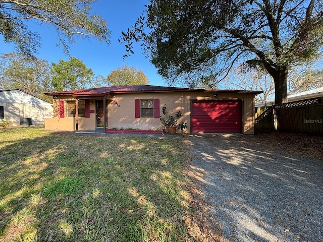 ranch-style home featuring a garage and a front lawn