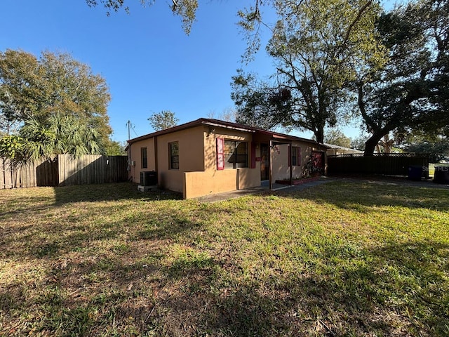 view of side of home featuring central AC and a lawn