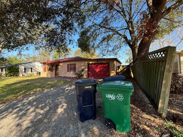 view of side of property with a garage and a lawn