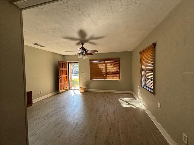 spare room featuring a textured ceiling, wood-type flooring, and ceiling fan