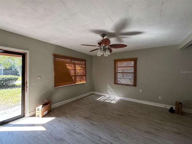 empty room with ceiling fan, hardwood / wood-style floors, and a textured ceiling