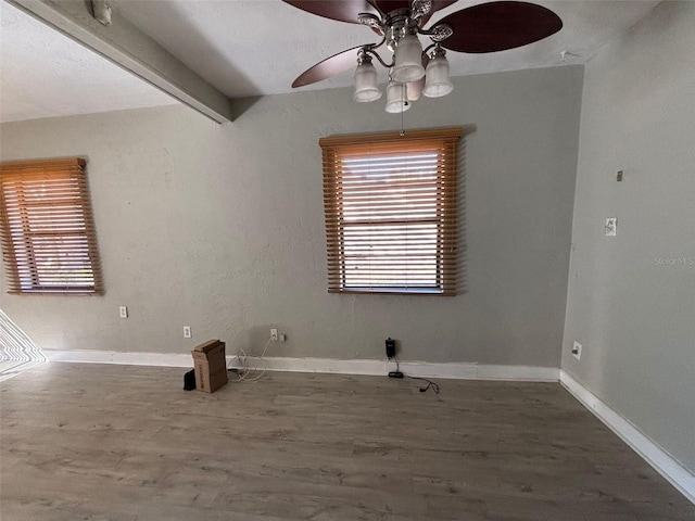 unfurnished dining area with ceiling fan, hardwood / wood-style floors, and beam ceiling