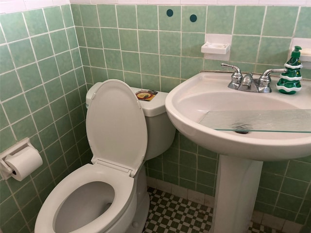 bathroom featuring tile walls and toilet