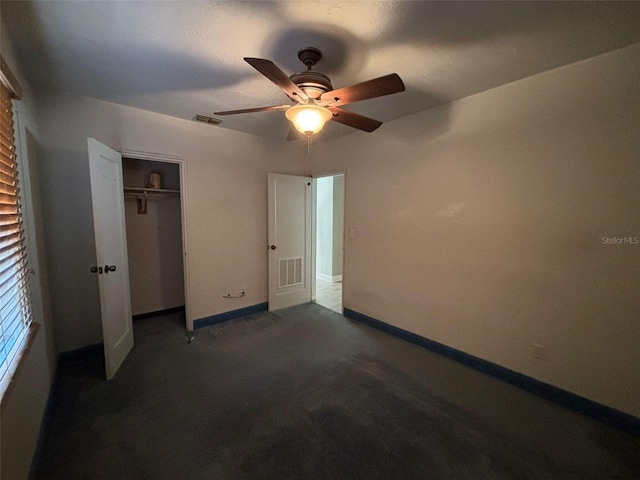 unfurnished bedroom with ceiling fan, dark carpet, and a closet