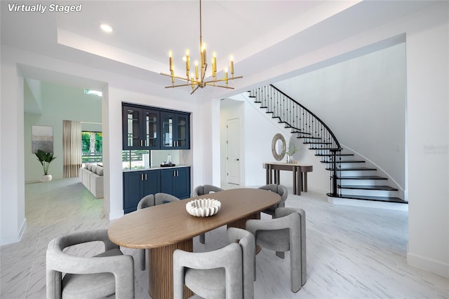 dining space featuring a tray ceiling and a chandelier