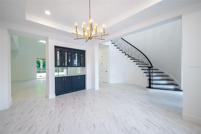 interior space with a raised ceiling and an inviting chandelier