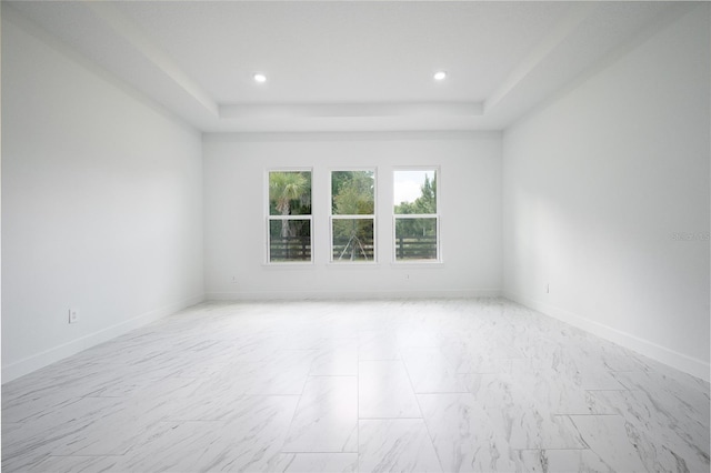 unfurnished room featuring a tray ceiling