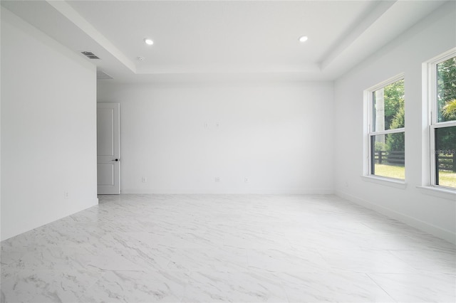 spare room with a tray ceiling