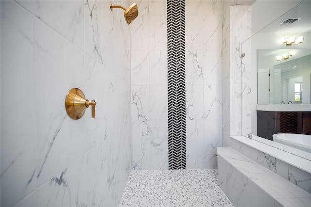 bathroom with vanity and tiled shower