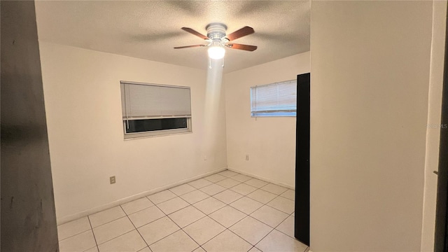 unfurnished room featuring ceiling fan, light tile patterned floors, and a textured ceiling