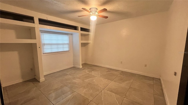 unfurnished bedroom featuring ceiling fan and a textured ceiling