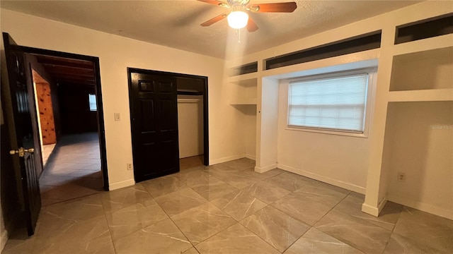 unfurnished bedroom with ceiling fan, a closet, and a textured ceiling