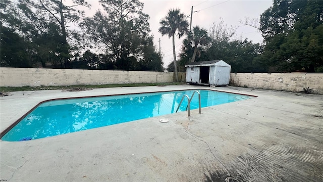 view of swimming pool with a storage unit and a patio