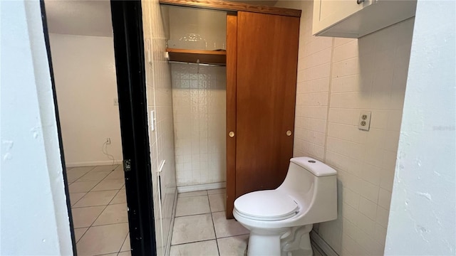 bathroom with tile walls, tile patterned floors, and toilet