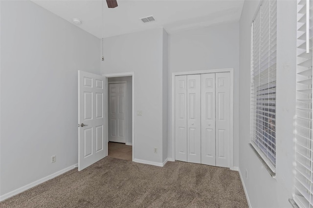 unfurnished bedroom with ceiling fan, a closet, and carpet