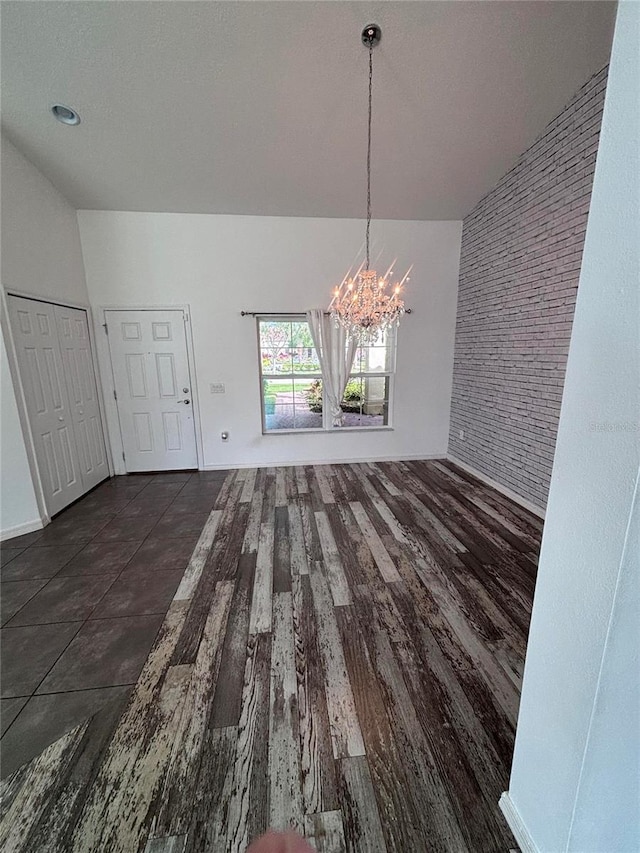 unfurnished dining area featuring an inviting chandelier and dark hardwood / wood-style floors