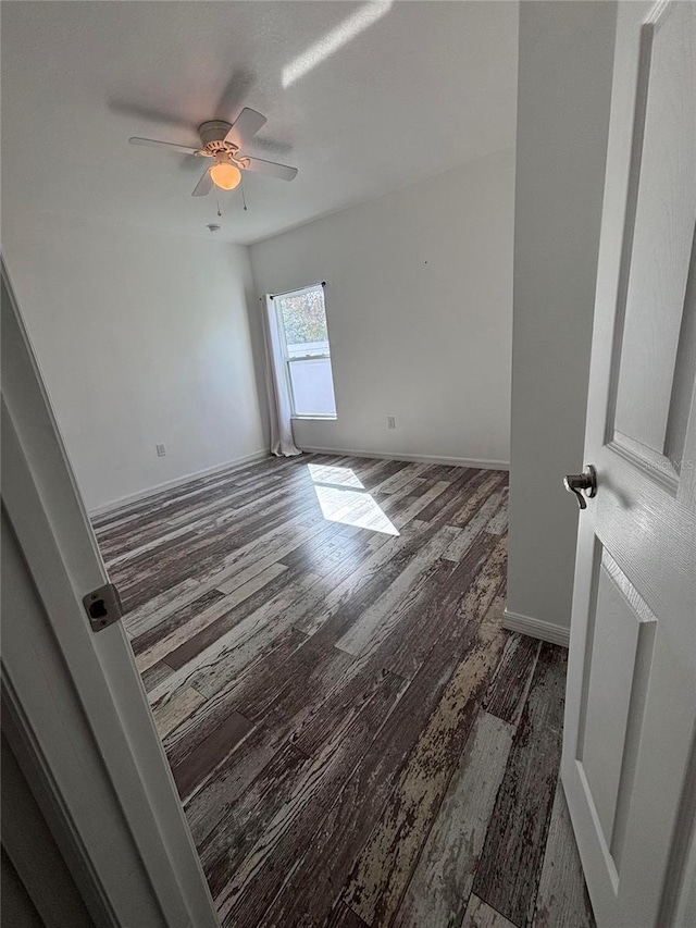 unfurnished room with ceiling fan and dark hardwood / wood-style flooring