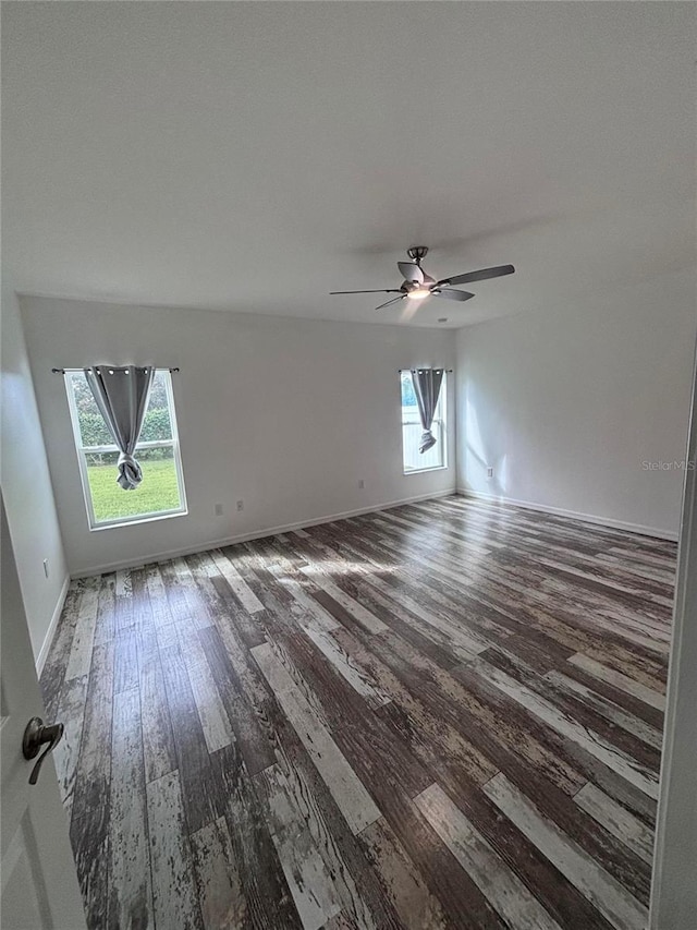 unfurnished room featuring dark wood-type flooring and ceiling fan