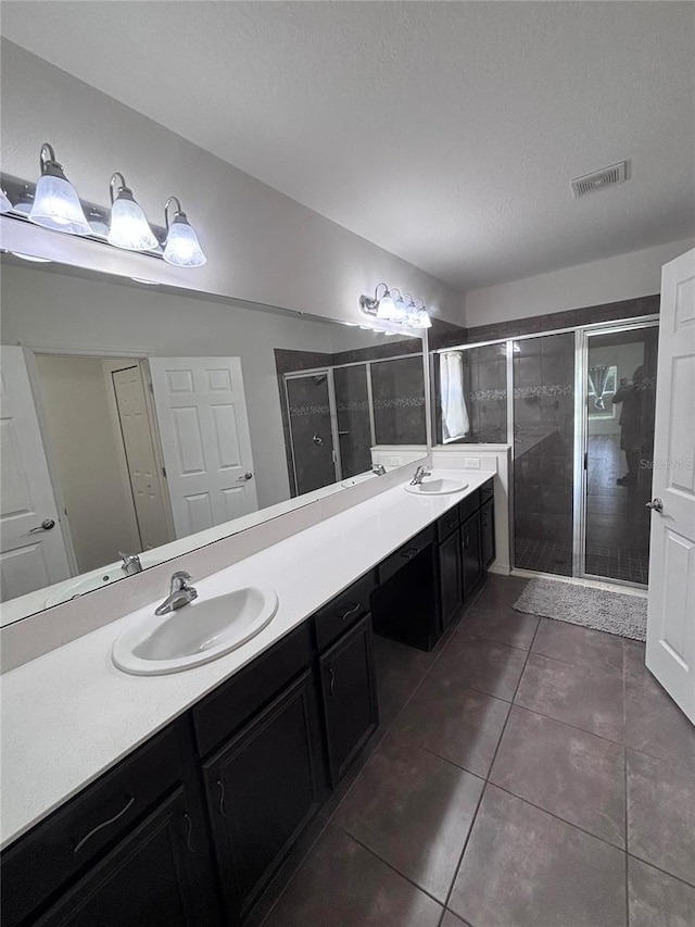 bathroom featuring vanity, tile patterned floors, a textured ceiling, and walk in shower