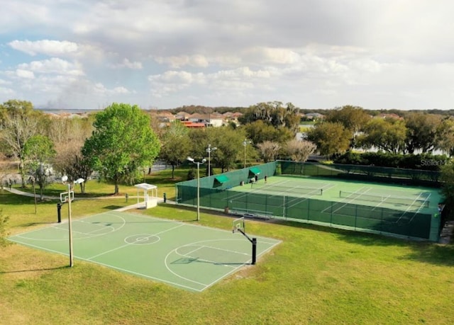 view of basketball court featuring tennis court and a lawn