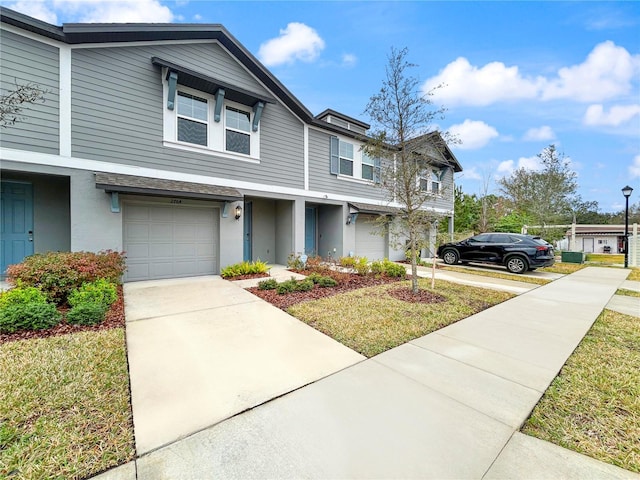 view of property featuring a garage and a front yard