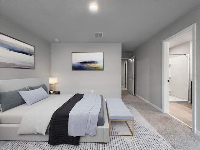 bedroom with light colored carpet and ensuite bath