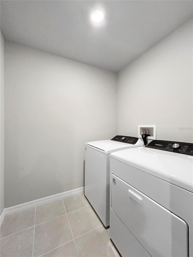 washroom featuring washer and clothes dryer and light tile patterned floors