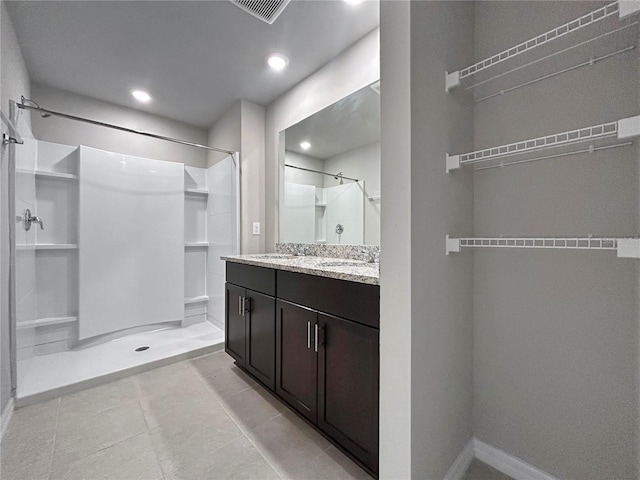 bathroom with tile patterned floors, vanity, and a shower