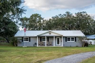 ranch-style home featuring a front yard and covered porch