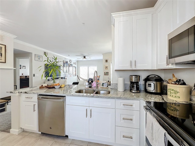 kitchen with sink, white cabinetry, crown molding, light stone counters, and stainless steel appliances