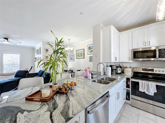 kitchen featuring sink, crown molding, white cabinetry, stainless steel appliances, and light stone countertops