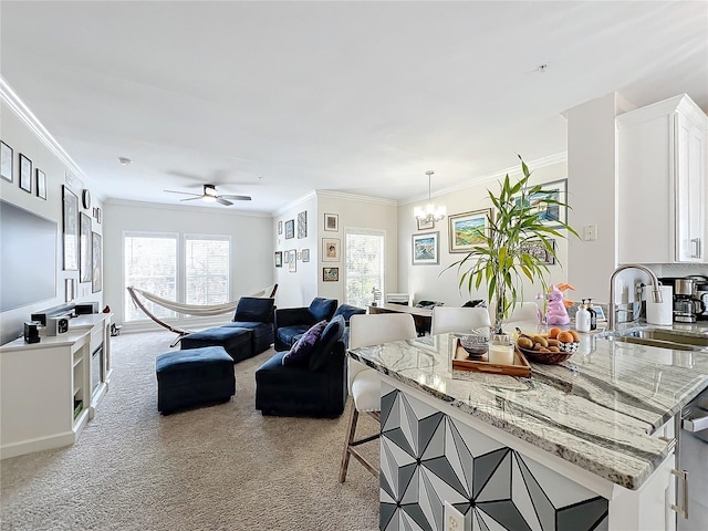 living room featuring light carpet, sink, plenty of natural light, and ornamental molding