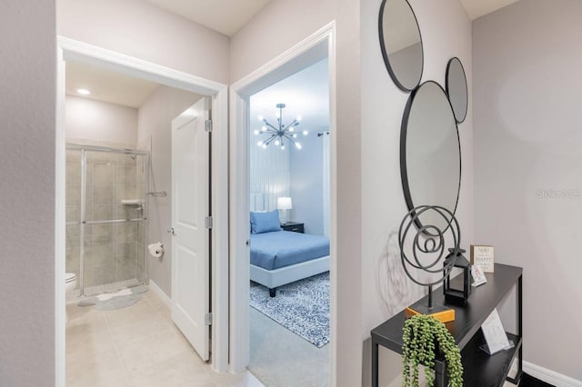 bathroom featuring an inviting chandelier, a shower with shower door, tile patterned floors, and toilet