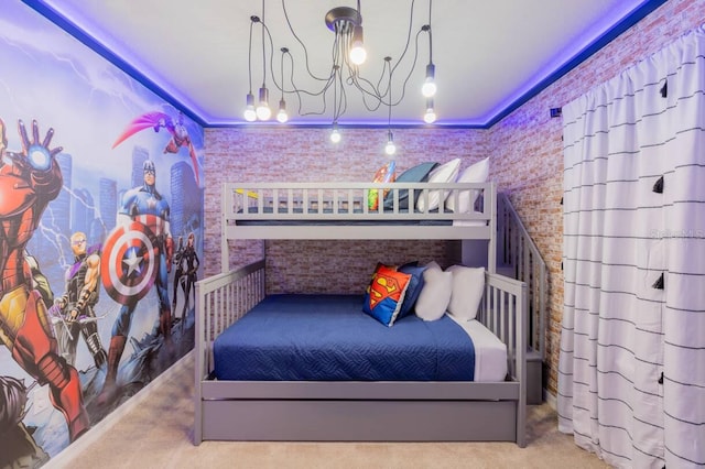 bedroom with an inviting chandelier, ornamental molding, brick wall, and carpet flooring