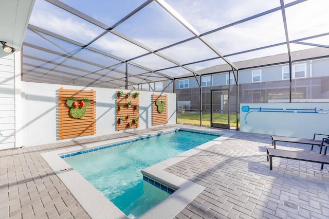 view of swimming pool featuring a patio and glass enclosure