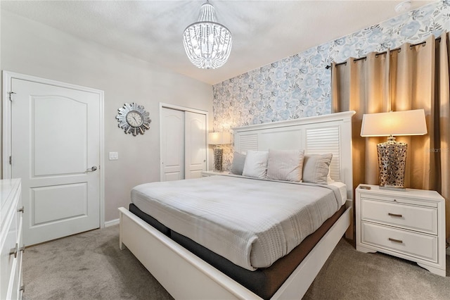 bedroom featuring an inviting chandelier, carpet floors, and a closet