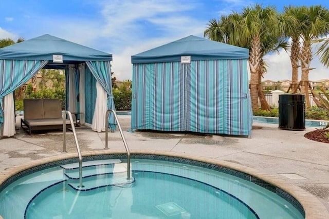 view of pool featuring a hot tub and a patio