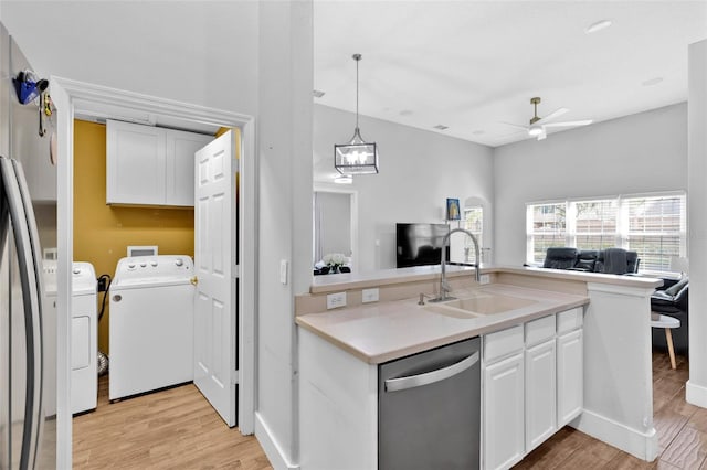 kitchen with washer and dryer, dishwasher, white cabinetry, sink, and light wood-type flooring