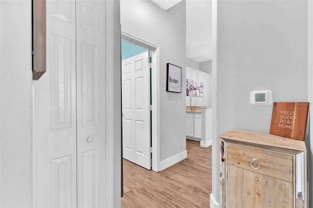 corridor featuring sink and light hardwood / wood-style floors