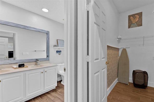 bathroom featuring hardwood / wood-style flooring, vanity, and toilet