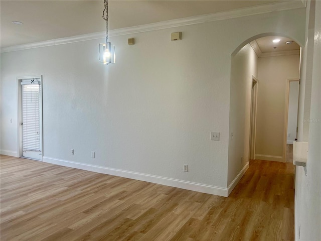 empty room featuring ornamental molding and light hardwood / wood-style floors