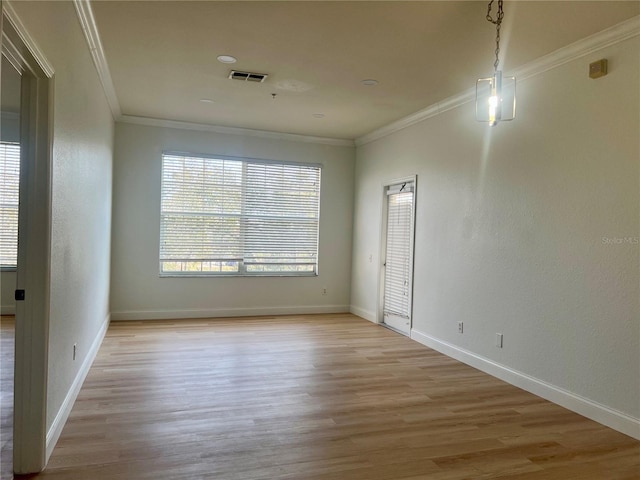 spare room featuring crown molding and light wood-type flooring