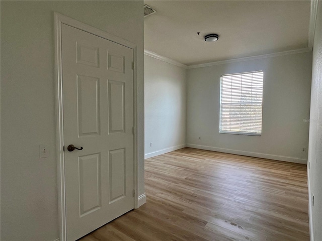 empty room featuring crown molding and light hardwood / wood-style flooring