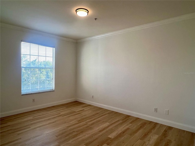 spare room featuring hardwood / wood-style flooring and ornamental molding