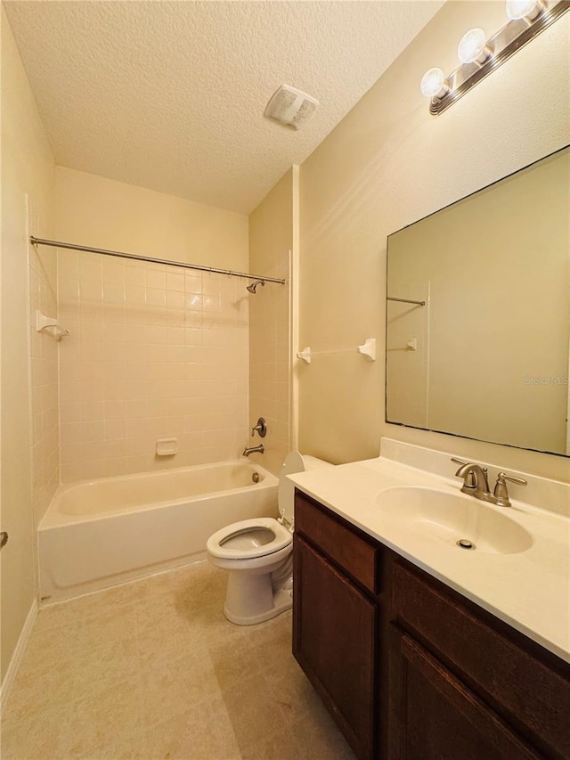 full bathroom featuring tiled shower / bath combo, vanity, a textured ceiling, and toilet