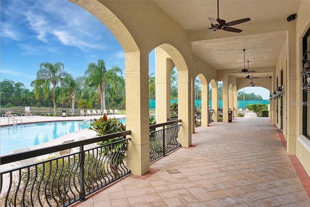 view of patio / terrace featuring a water view, a community pool, and ceiling fan