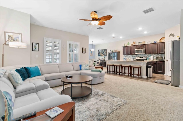 carpeted living room featuring ceiling fan